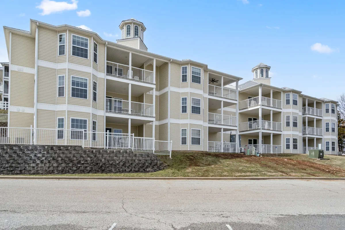 This exterior shot presents the condo buildings with inviting balconies and landscaped surroundings. The visible patios and green yards suggest private outdoor spaces for guests and their pets to relax together.